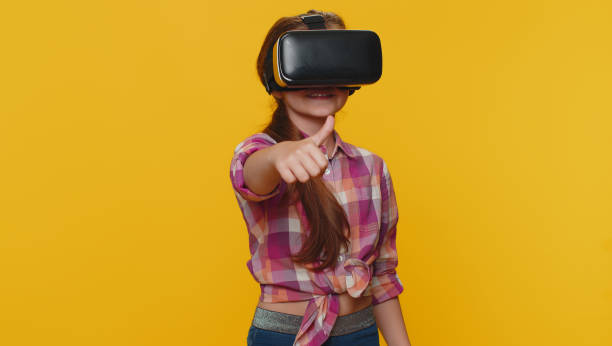 istock Child girl kid using virtual reality VR app headset to play simulation 3D video game watching video 1414223343