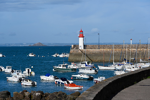 Erquy, France, June 26, 2022 - Port and lighthouse at high tide of Erquy, a commune in the Côtes-d'Armor department of Brittany in northwestern France on the côte de Penthièvre.
