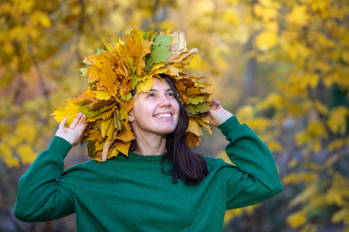 beautiful woman portrait with maple leaf wreath on the head autumn season