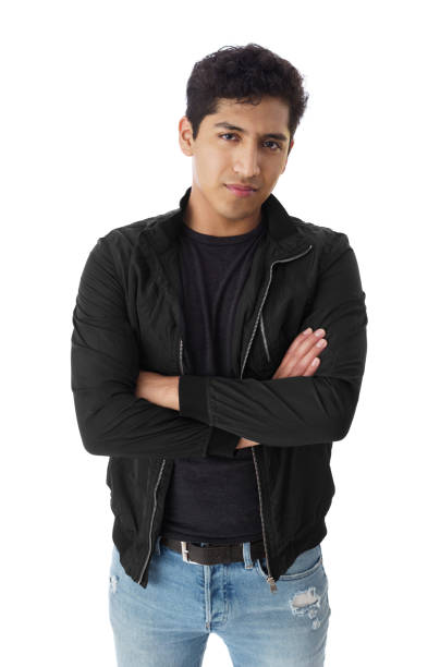 An attractive man in his 20s wearing a black tshirt standing with his arms crossed against a white background.