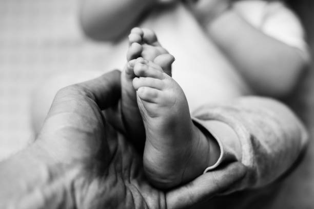 istock Baby's feet in father's hands 1414233178