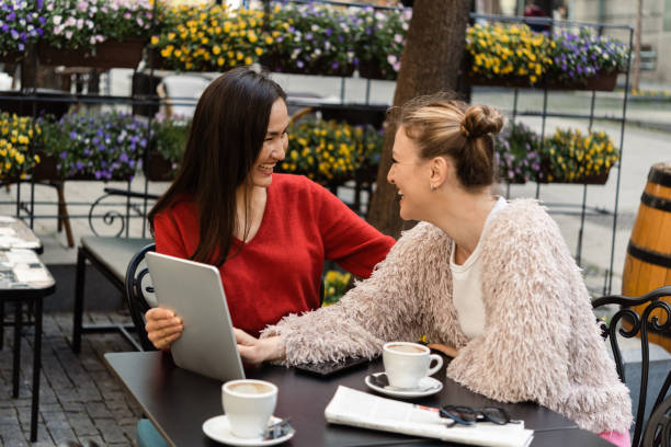 istock Two best female friends enjoying at the cafe and using tablet 1414236439
