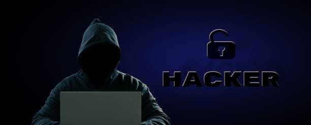 istock Dangerous anonymous hackers are using laptops for identity theft. The back is black and blue and has text. ''HACKER'' with keys unlocked. cyber crime cyber attack, system destruction 1414236548