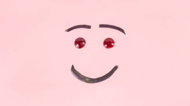 istock Smiley face made from purple asparagus beans and cherries. 1414238305