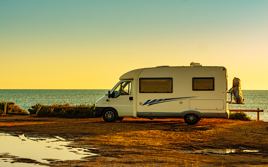 Camper, recreational vehicle camping on beach, mediterranean coast in Spain. Holidays and travel in motorhome.