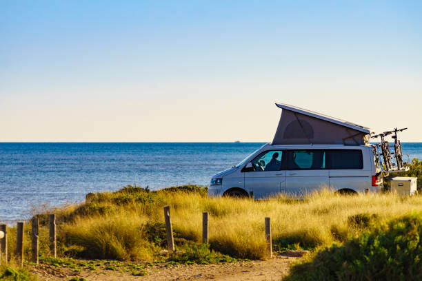 Camper van with roof top tent camp on beach stock photo