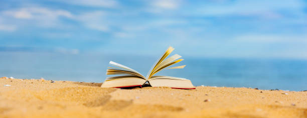 istock Book on beach with blue sea in background 1414243850