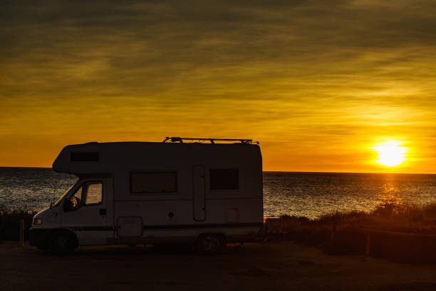 istock Camper car on beach at sunrise 1414244088