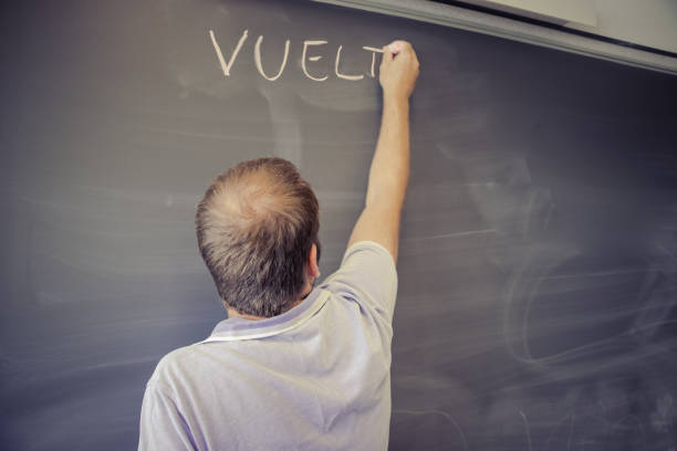 teacher writing on the blackboard in a school, back to school