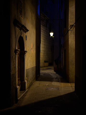 Cres, Croatia - April 11, 2022: Narrow street in Cres with old streetlamps during night