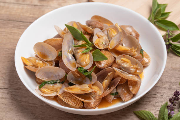 istock Stir fried clams with basil leaves in a white bowl 1414248585