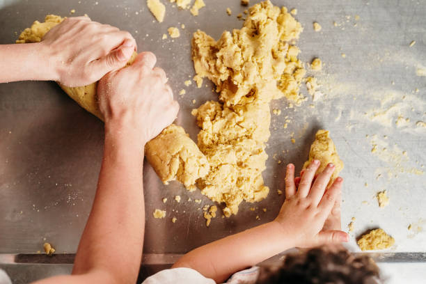 istock Top view of mother's and son's hands kneading dough 1414248689