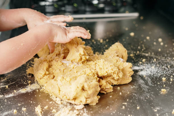 Child's hands mixing dough for arepas stock photo