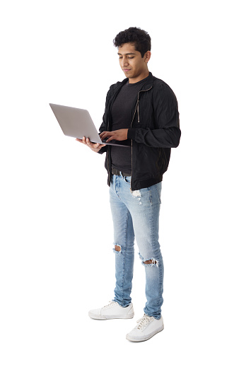 Side view of a male student holding and using a laptop computer with a smile.
