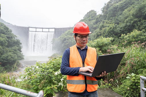 A male engineer works with a laptop in a hydropower station