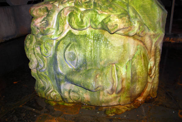 Istanbul, Turkey / Türkiye: Basilica-Cistern - built under emperor Justinian I - underground water reservoir - stone head of Greek mythological figure Medusa on its side, recycled as a building material, supports a pillar - Yerebatan Sarayi - Yerebatan Caddesi, Sultanahmet, Fatih.