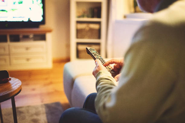 istock Senior friendly gentleman is sitting and watching TV 1414255098