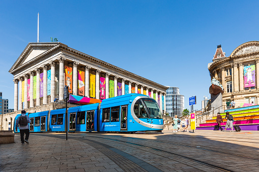 Birmingham, UK - July 28, 2022.  A West Midlands Metro Tram travelling along tracks at Victoria Square in Birmingham city centre during The Commonwealth games