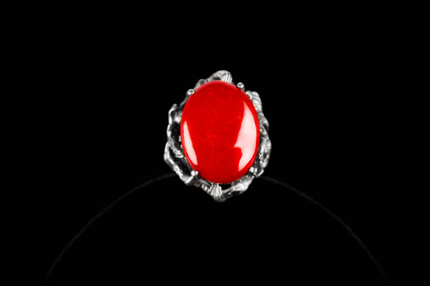 istock Silver ring with coral stone on black background. 1414256130