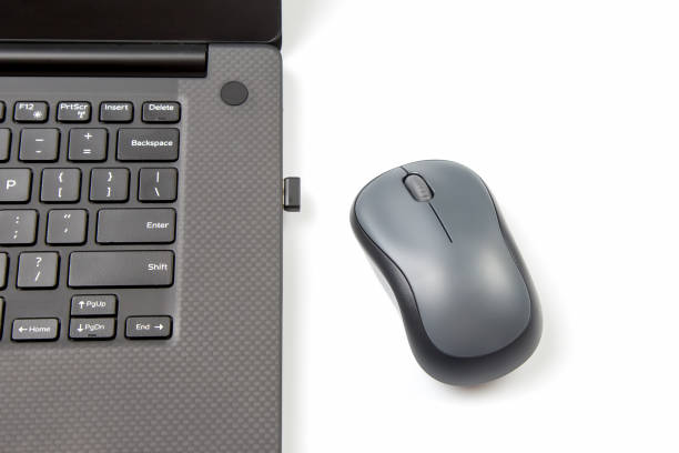 istock Computer wireless mouse next to a laptop on a white table close-up. electronic personal industry 1414258504