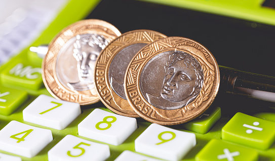 Brazilian Real coins on a green calculator. Concepts of Brazilian economy and finance.
