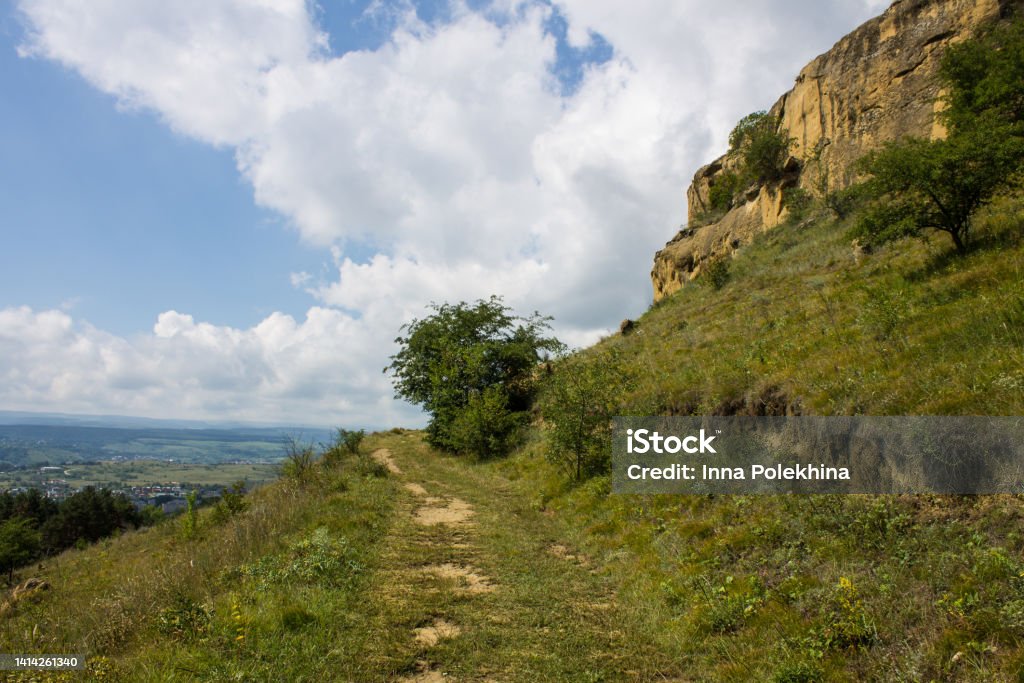 landscape with a mountain path, a cliff and a green tree A beautiful landscape with a mountain path, a cliff and a green tree on a sunny summer day and a space to copy in Kislovodsk russia Adventure Stock Photo