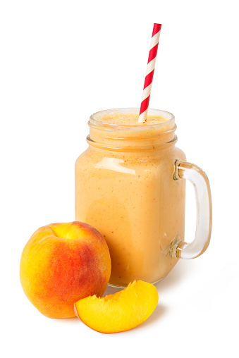 Peach smoothie of fresh peach and yogurt in a glass jar isolated on a white background.