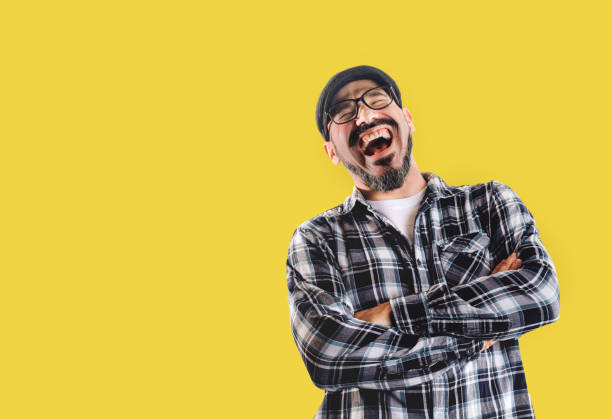 Man laughing very hard isolated on yellow background Man laughing very hard isolated on yellow background. Good mood, jokes and happiness people laughing hard stock pictures, royalty-free photos & images