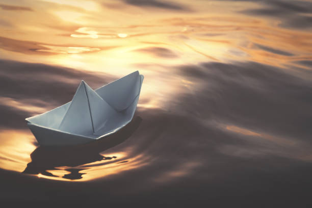 istock White paper boat floating on river. Retro photo effect 1414263472