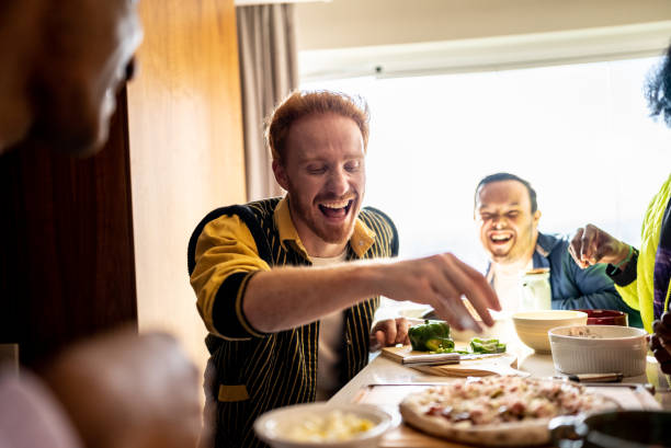 istock Young man making pizza with friends at home - including a person with special needs 1414263602
