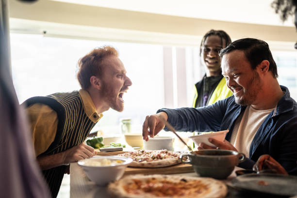 istock Friends making pizza at home - including a person with special needs 1414263625