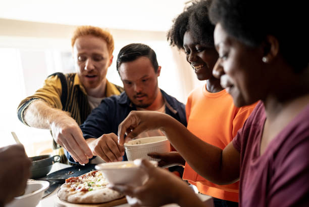 istock Friends making pizza at home - including a person with special needs 1414263665