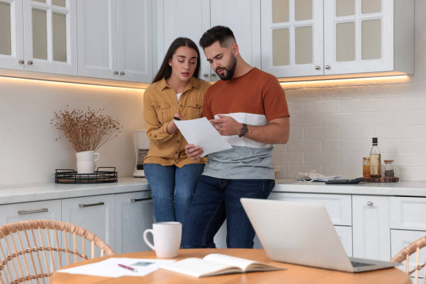 istock Young couple discussing family budget in kitchen 1414265259