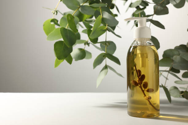 istock Bottle of liquid soap on white table near eucalyptus branches, space for text 1414265402