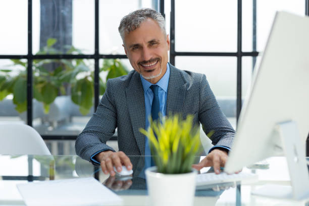 istock Mature businessman working on computer in modern office. 1414266423