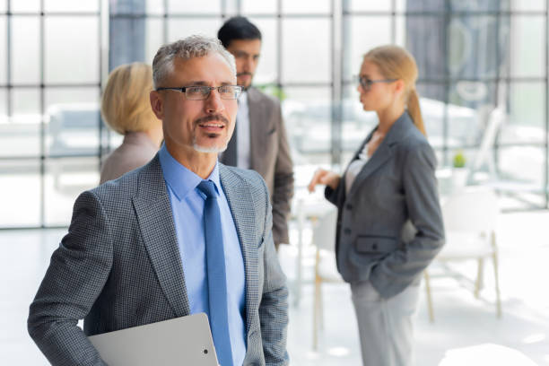 istock Businessman with colleagues in the background in office. 1414266489