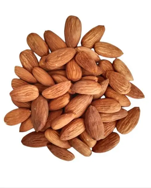 Image of Almond Badam, an edible and widely cultivated sweet nut of  Prunus dulcis tree, in heap in white background.