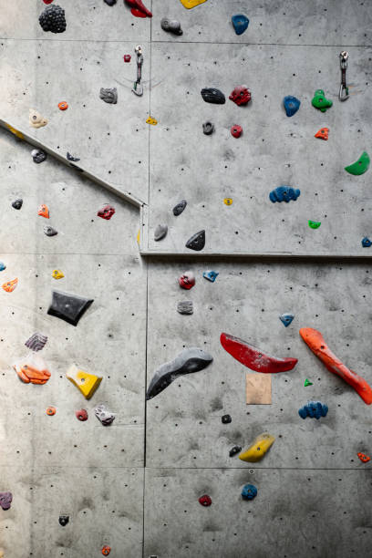 istock Rock climbing wall with climbing holds in gym 1414269087