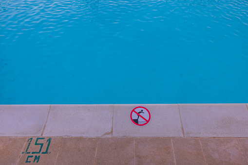 Close up view of warning sign on outdoor swimming pool.