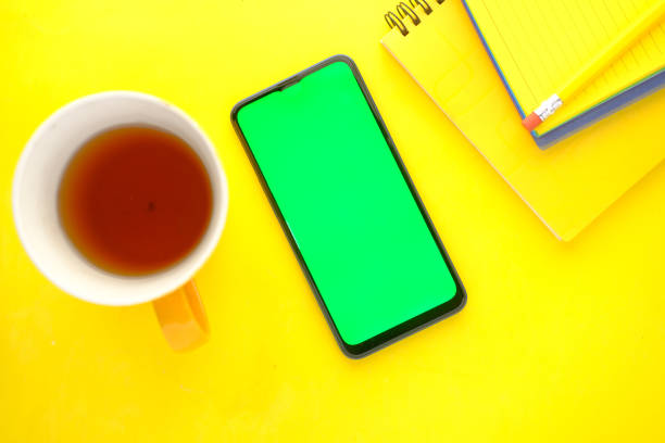 istock top view of smart phone, coffee mug and notepad on yellow background 1414272383