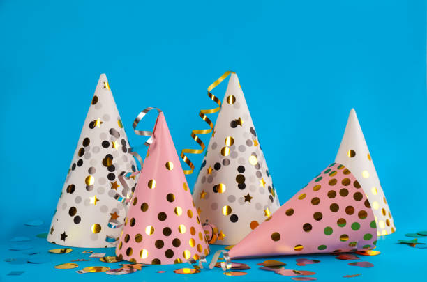 istock Colorful party hats and confetti on light blue background 1414273882