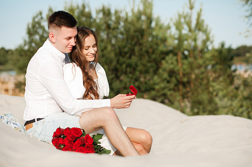 A marriage proposal.
A couple in love hugging on the background of a sand quarry.