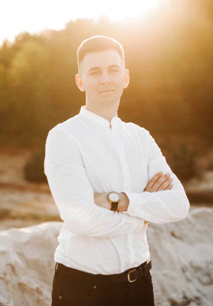 istock Handsome guy in white shirt and black pants at sunset 1414275998