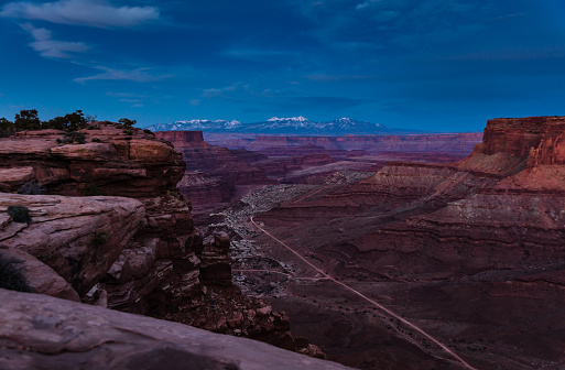 Time lapse of Canyonlands National Park in Utah,  looking down on Shafer Canyon in the Island in the Sky district. The famous Shafer Canyon Trail is visible on the valley floor down below, and in the distance are the snowcapped peaks of the La Sal Mountains. This image is part of a series of views taken at different times of day from the same location; a time lapse is also available.