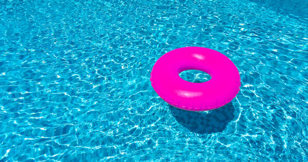 istock Pink ring floating in blue swimming pool. Inflatable ring, rest concept 1414278462