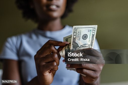 istock Close up of a woman counting money 1414279526