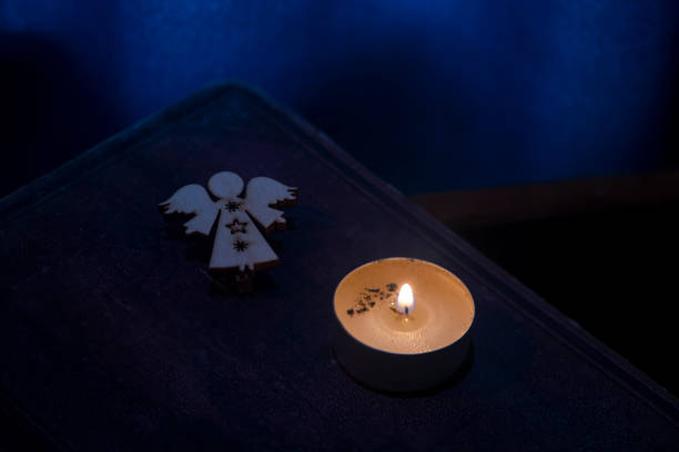 vela, libro, estatuilla de ángel. - christmas candle reflection red fotografías e imágenes de stock