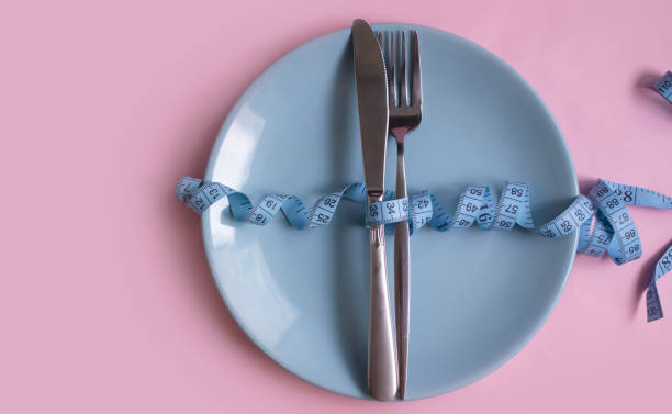 istock Fork, knife, measuring tape on a colored background 1414281529