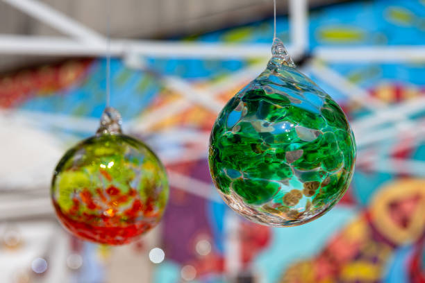 Colorful hanging glass balls with selective focus on the green ball in the foreground.  Concepts could include art, decor, holiday, others.