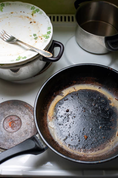 istock greasy old pan and dirty dishes on a stove 1414282531